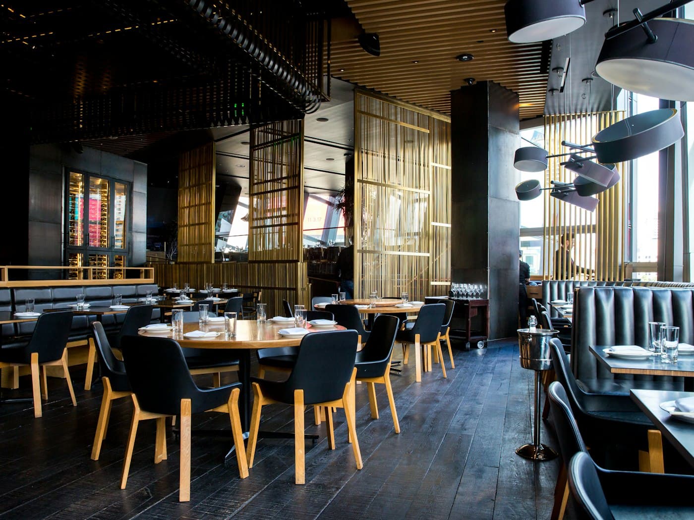 The dining room at Anthrakas, with dark wood, leather banquettes and warm light
